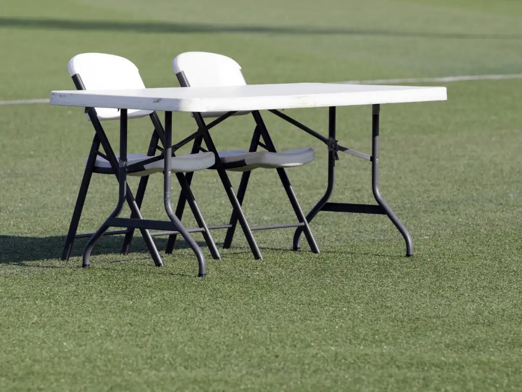 Tables and chairs set up in a backyard for a birthday party.